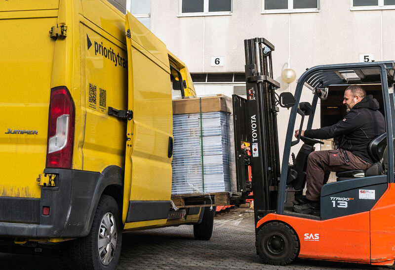 Operatore logistico Asendia carica pacchi.